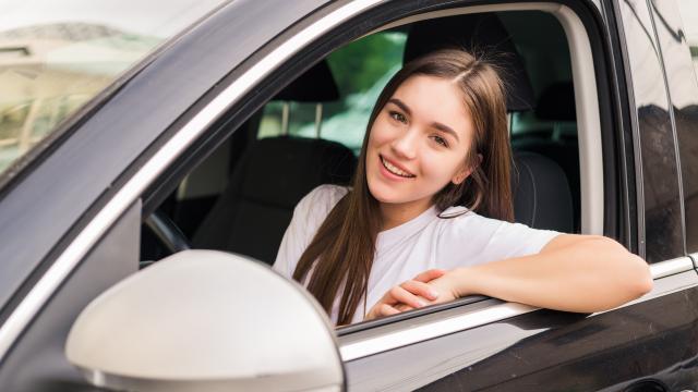 young-pretty-woman-driving-her-car-on-trip-road.jpg